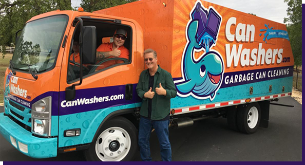 Two men giving thumbs-up beside cleaning truck